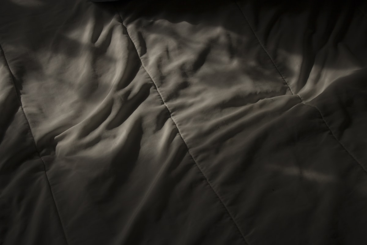 a black and white photo of a blanket related to Coverlet vs Bedspread: Which One Should You Choose?