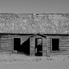 A black and white photograph of an abandoned homestead in an open field in rural Gem Valley, Idaho, USA, related to Western Window Valances: Add a Touch of Rustic Charm