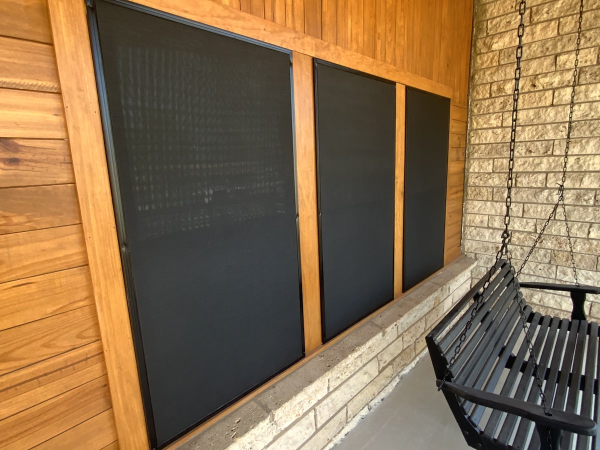A black bench sitting next to a brick wall related to Black Valance with Grommets