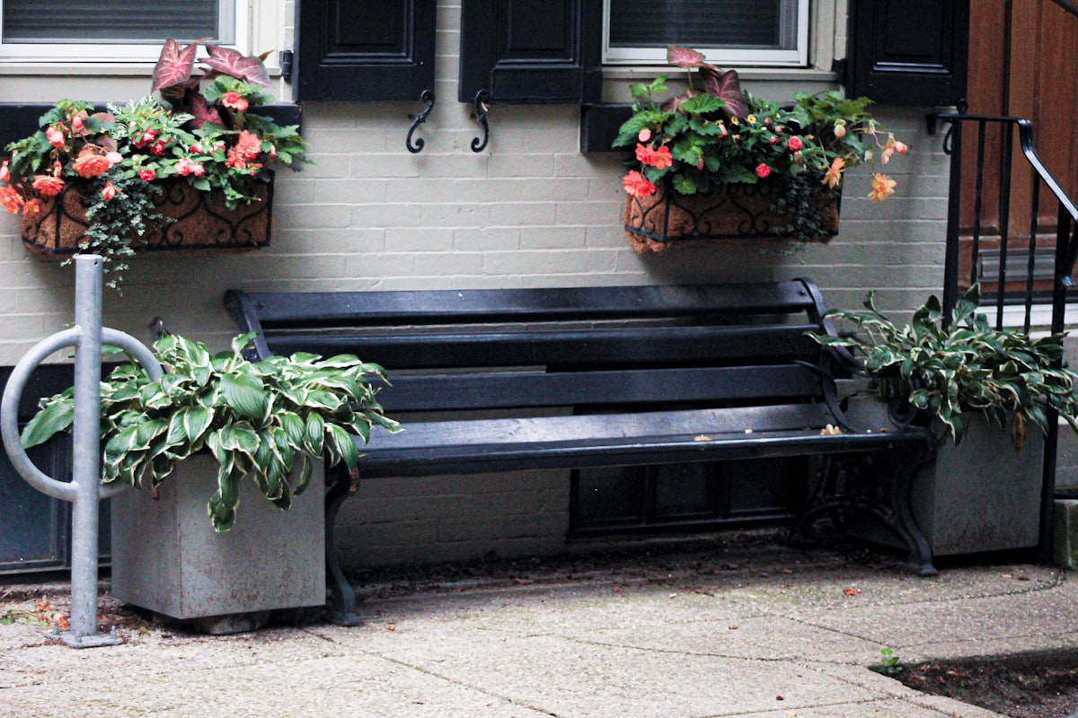 a black bench with two planters on top of it related to Cozy Up Your Entryway with Functional Benches and Baskets