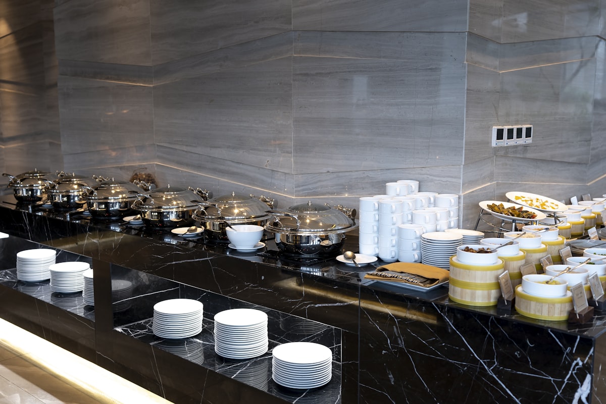 a black counter with plates and bowls on it related to Marble Top Sideboards and Buffets: Timeless Elegance for Any Home