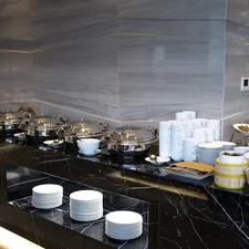 a black counter with plates and bowls on it related to Marble Top Sideboards and Buffets: Timeless Elegance for Any Home