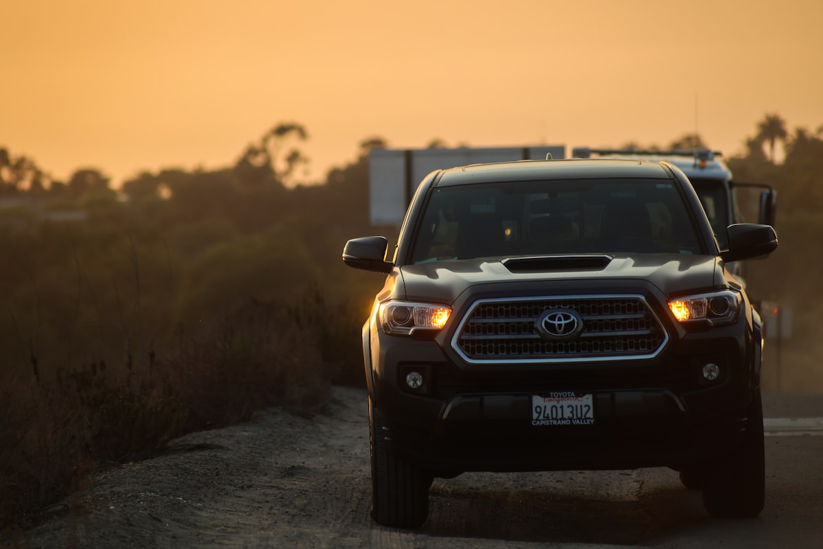 a black truck driving down a dirt road related to Maximizing Your Pickup's Potential: Tacoma Bed Extender Options