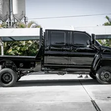 a black truck parked in front of a factory related to Find the Perfect Used Utility Bed for Your Needs