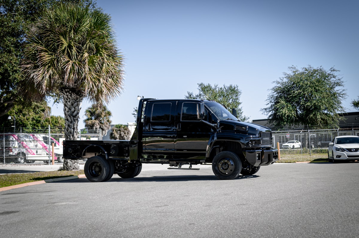 a black truck parked on the side of a road related to Revving Up Your Utility: The World of Custom Truck Beds