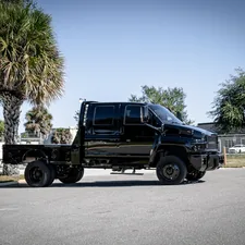 a black truck parked on the side of a road related to Revving Up Your Utility: The World of Custom Truck Beds