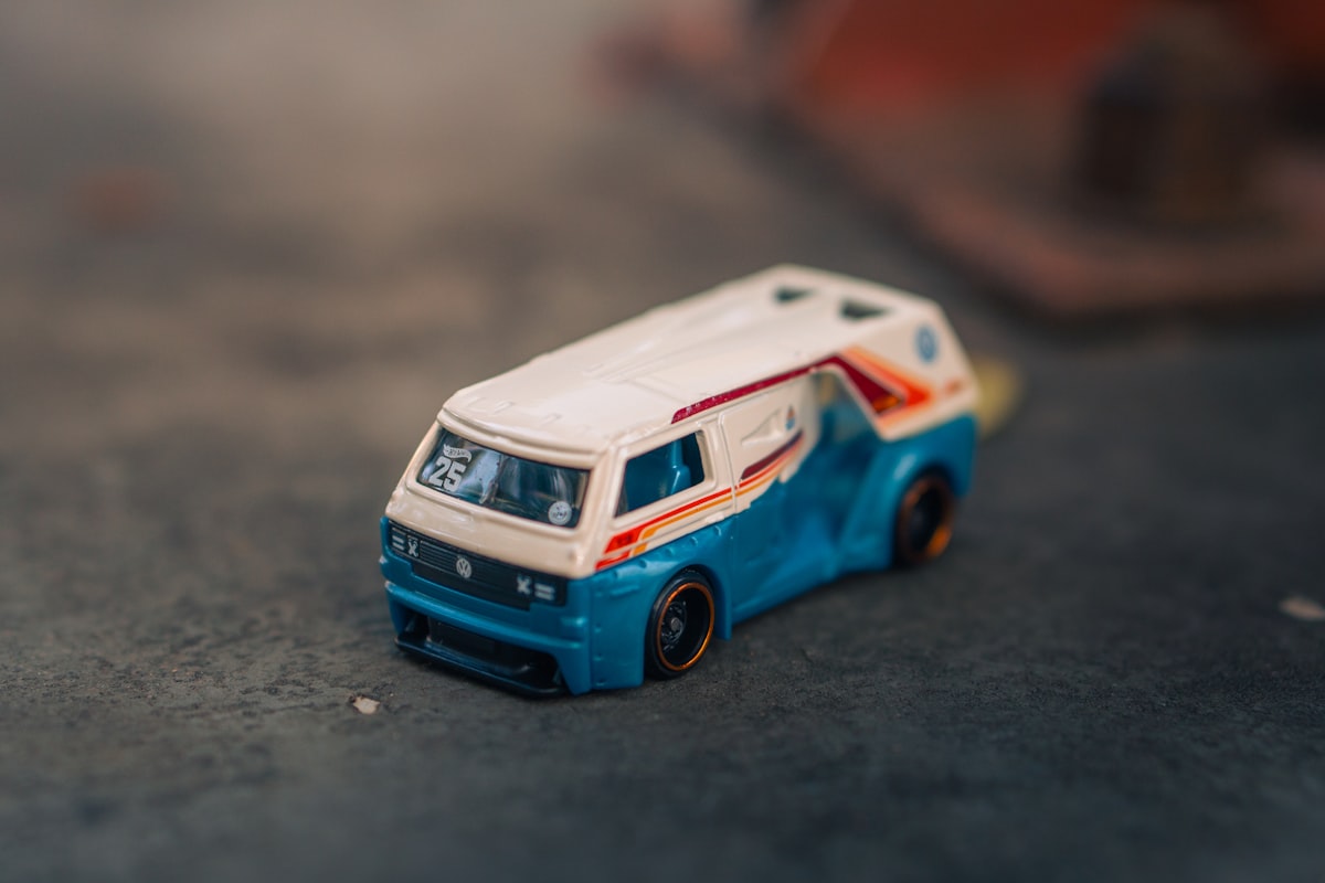 A blue and white toy van on a dark surface. related to Speed into Slumber with the Ultimate Hot Wheels Bedding Set