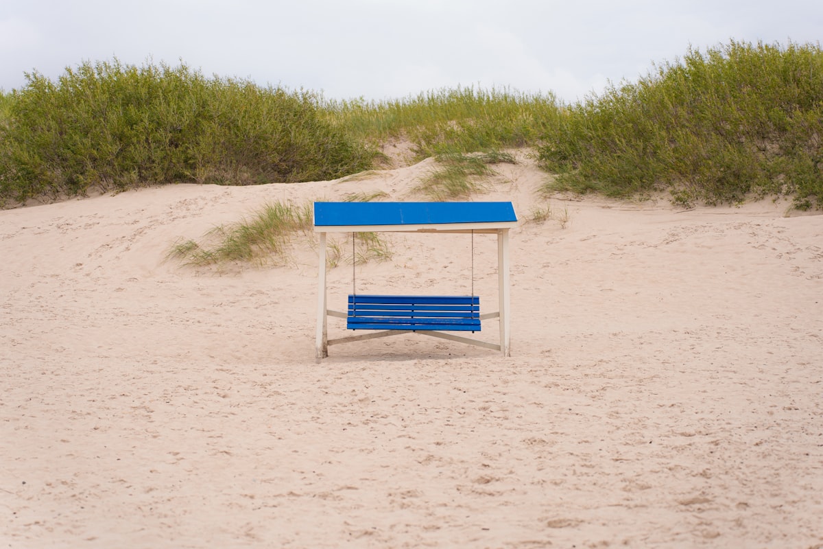 a blue bench sitting on top of a sandy beach related to Exploring the Charm and Functionality of Blue Bunk Beds