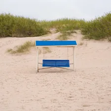 a blue bench sitting on top of a sandy beach related to Exploring the Charm and Functionality of Blue Bunk Beds