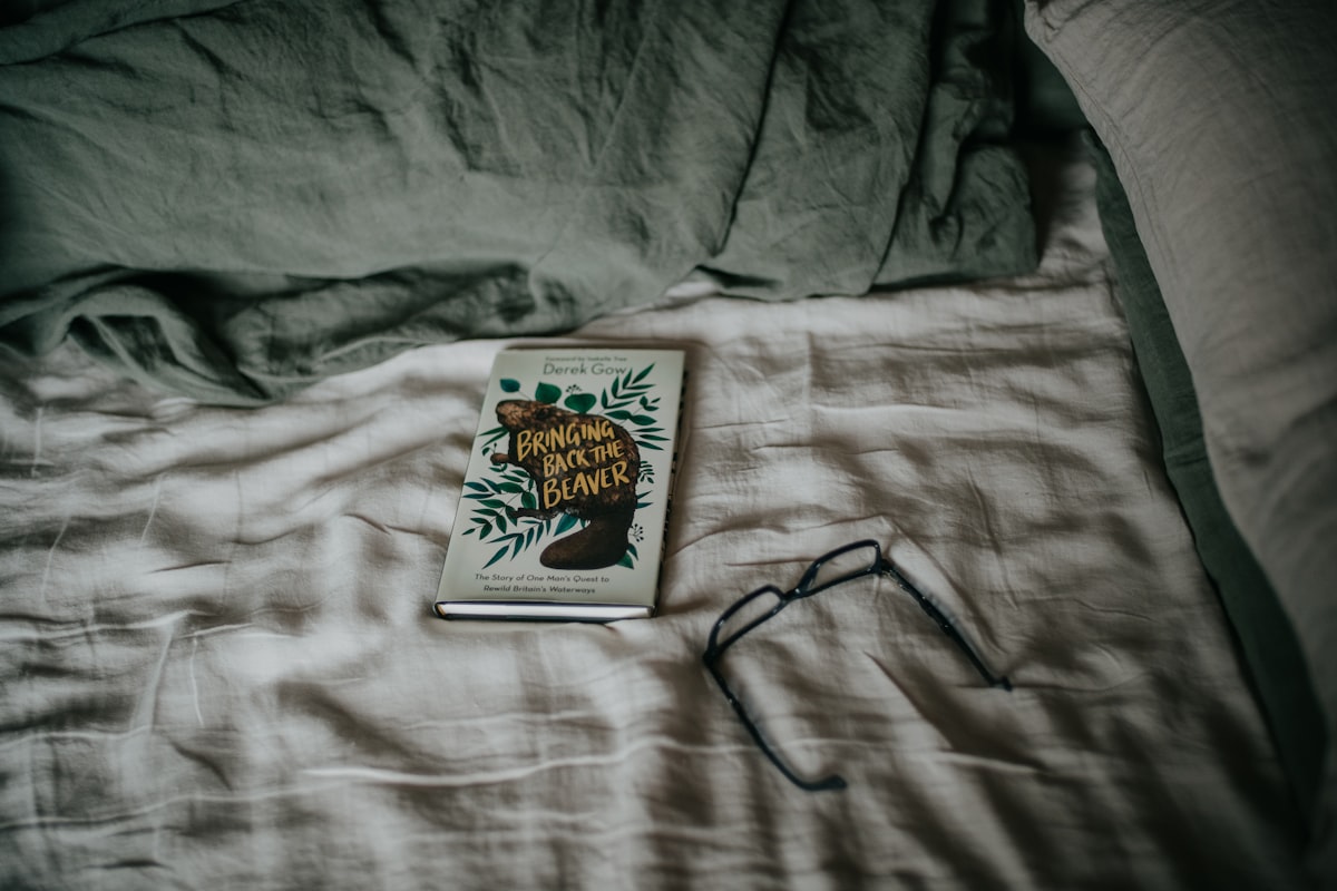 a book sitting on top of a bed next to a pair of glasses related to Unveiling the Perfect Coverlet: A Guide to King Size Comfort