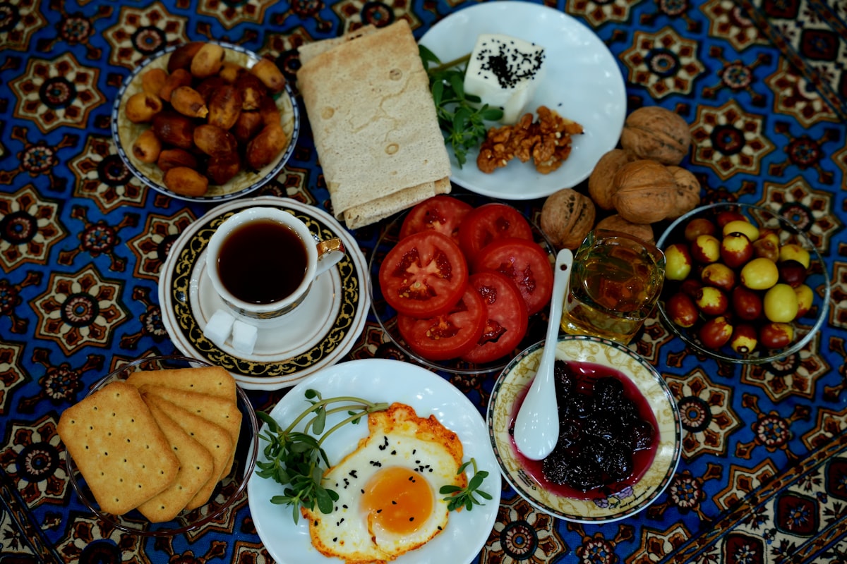 A breakfast spread with fried eggs, tea, dates, tomatoes, and jam on a patterned cloth related to Discovering the Charm of Islamorada Bed and Breakfasts