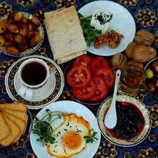 A breakfast spread with fried eggs, tea, dates, tomatoes, and jam on a patterned cloth related to Discovering the Charm of Islamorada Bed and Breakfasts