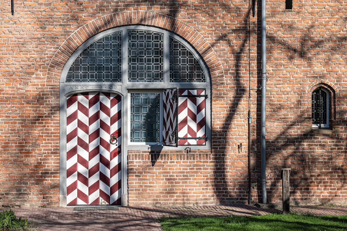 a brick building with a red and white striped door related to Chevron Window Valance: A Stylish Addition to Any Home
