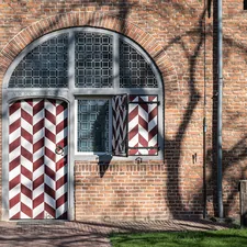 a brick building with a red and white striped door related to Chevron Window Valance: A Stylish Addition to Any Home