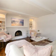 A bright, cozy living room with blush tones, gold accents, and a white brick fireplace, styled for calm and comfort. related to Transform Your Space with Stunning Blue Toile Valances