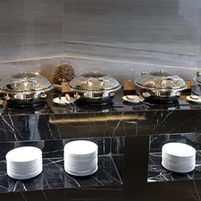 a bunch of plates that are sitting on a table related to Marble Top Sideboards and Buffets: Timeless Elegance for Any Home
