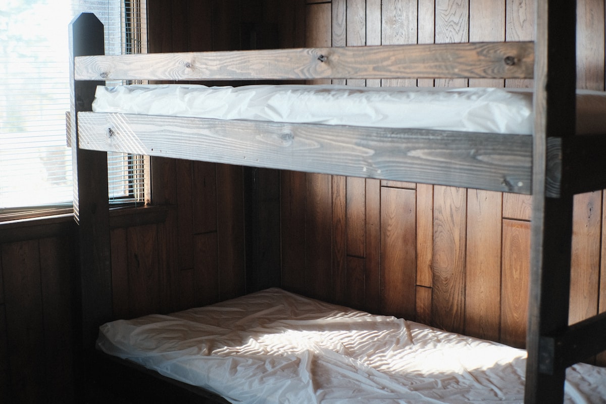 a bunk bed in a room with wooden walls related to Maximizing Bedroom Space with a Twin Over Full Bunk Bed