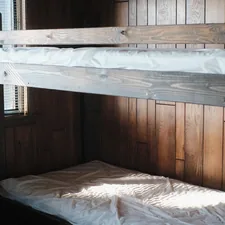 a bunk bed in a room with wooden walls related to Maximizing Bedroom Space with a Twin Over Full Bunk Bed