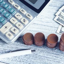 a calculator, pen, and money on a table related to Find Budget-Friendly Valances for Your Kitchen
