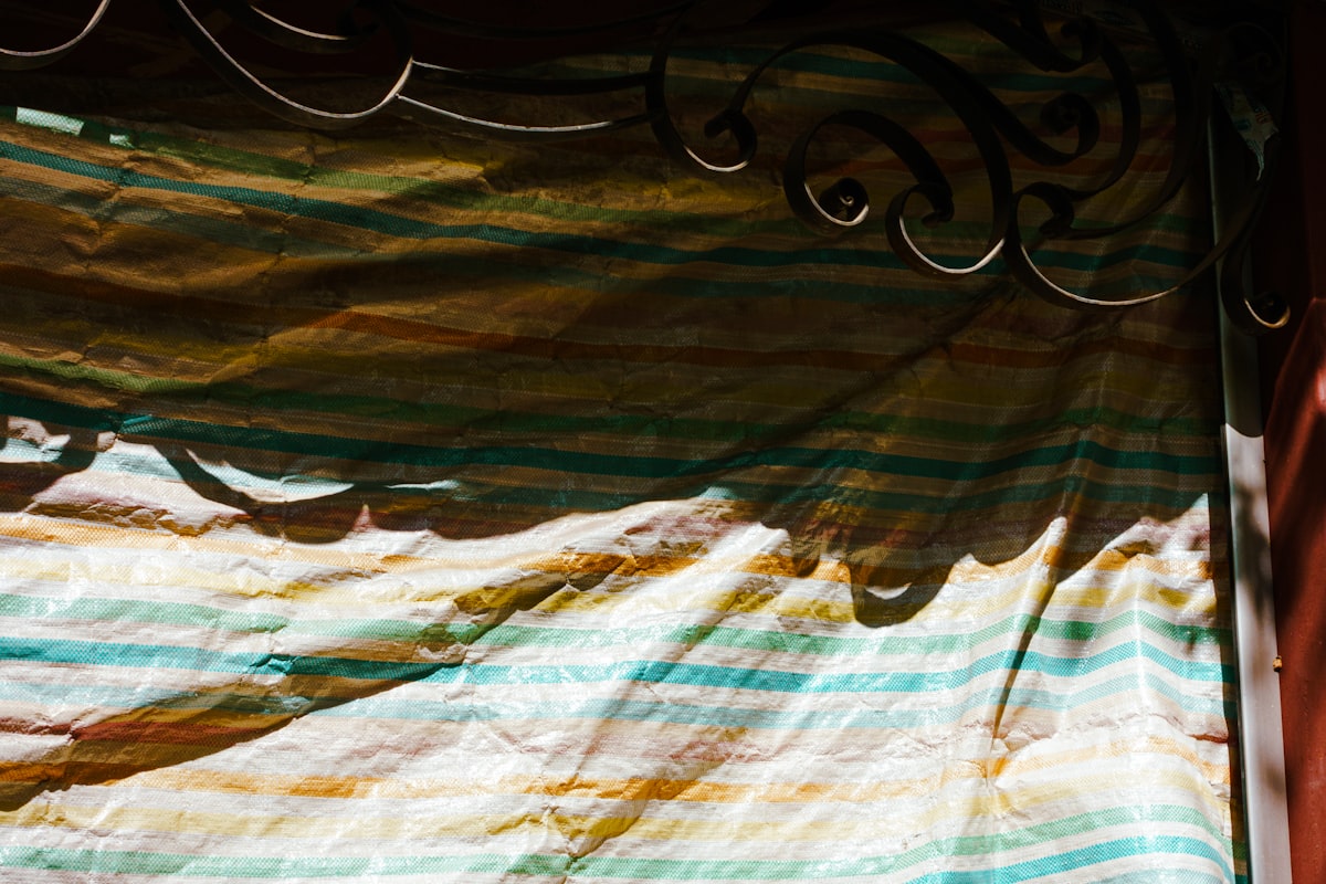 a cat is sitting on a bed in a room related to Striped Window Valances: Add a Pop of Pattern to Your Windows