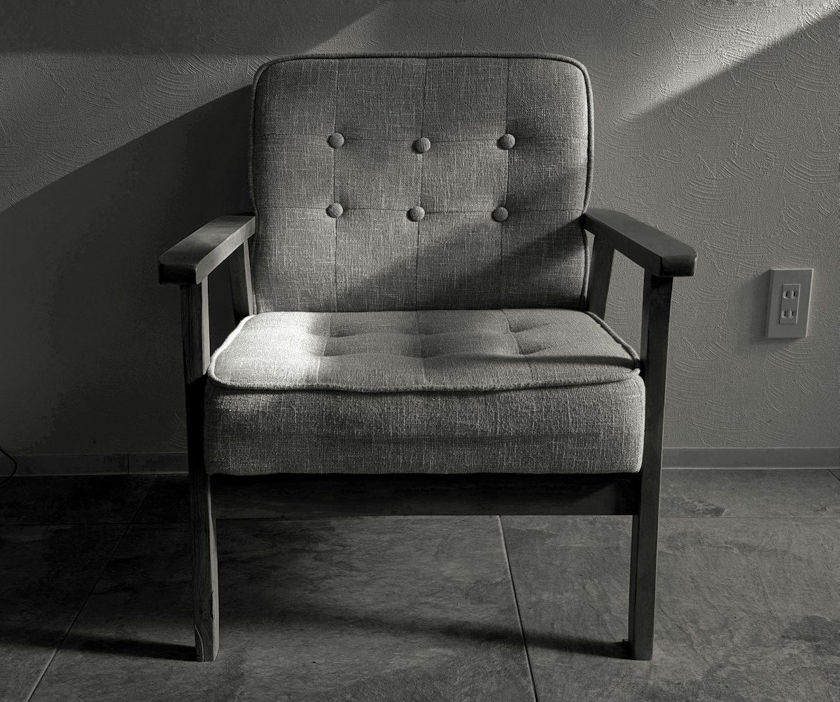 a chair sitting in a room next to a wall related to The Ultimate Guide to Pull Out Bed Chairs: Transforming Spaces with Style and Functionality