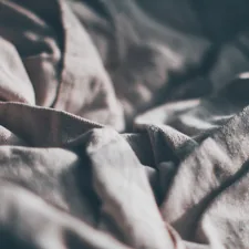 a close up of a bed with a white comforter related to Understanding the Difference Between Coverlet and Bedspread