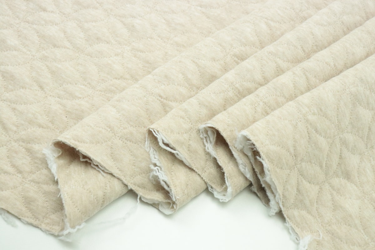 a close up of a blanket on a white surface related to Scalloped Matelasse Coverlet: Stylish Bedding Solution