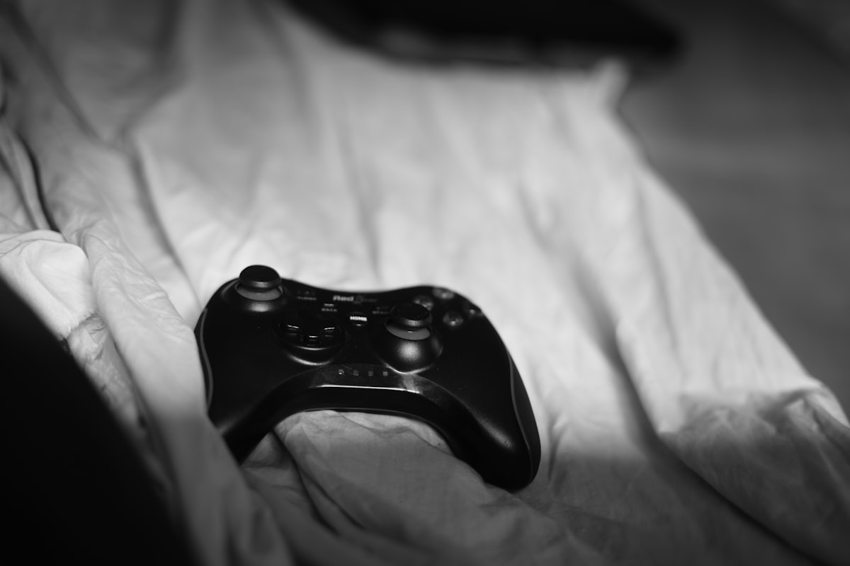 a close up of a controller on a bed related to Transform Your Bedroom with Fun Video Game Bedding