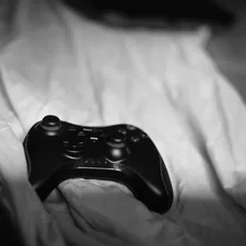 a close up of a controller on a bed related to Transform Your Bedroom with Fun Video Game Bedding