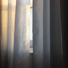 a close up of a curtain with a window in the background related to Window Treatments