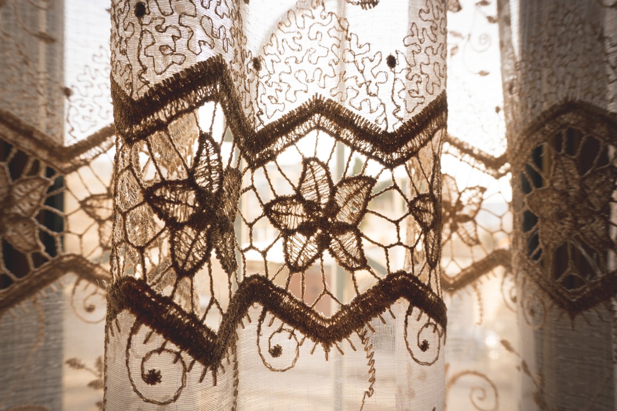 a close up of a lace curtain with a window in the background related to Valance Curtain Patterns