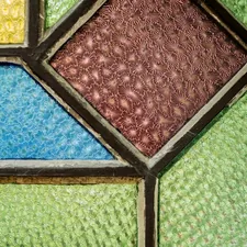 a close up of a multicolored stained glass window related to Elegance in Light: The Art of Stained Glass Valances