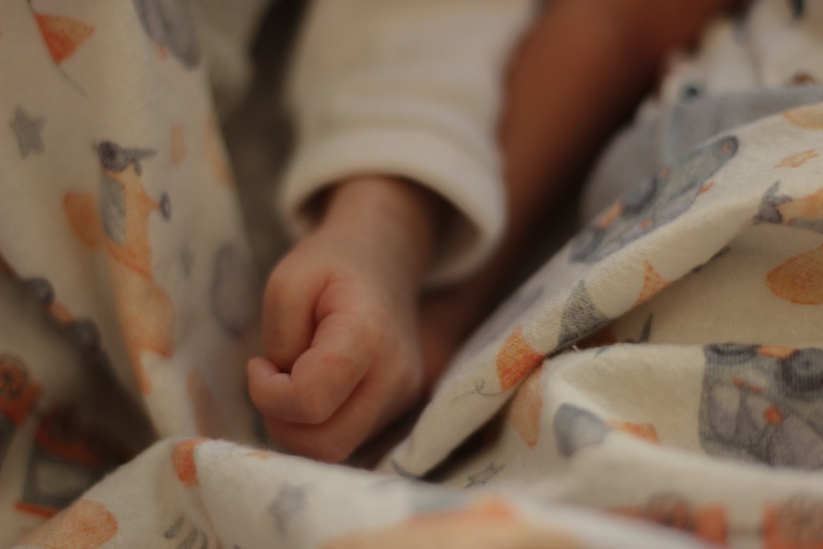 a close up of a person laying in a bed related to Noah's Ark Baby Bedding: Create a Whimsical Nursery with Timeless Charm