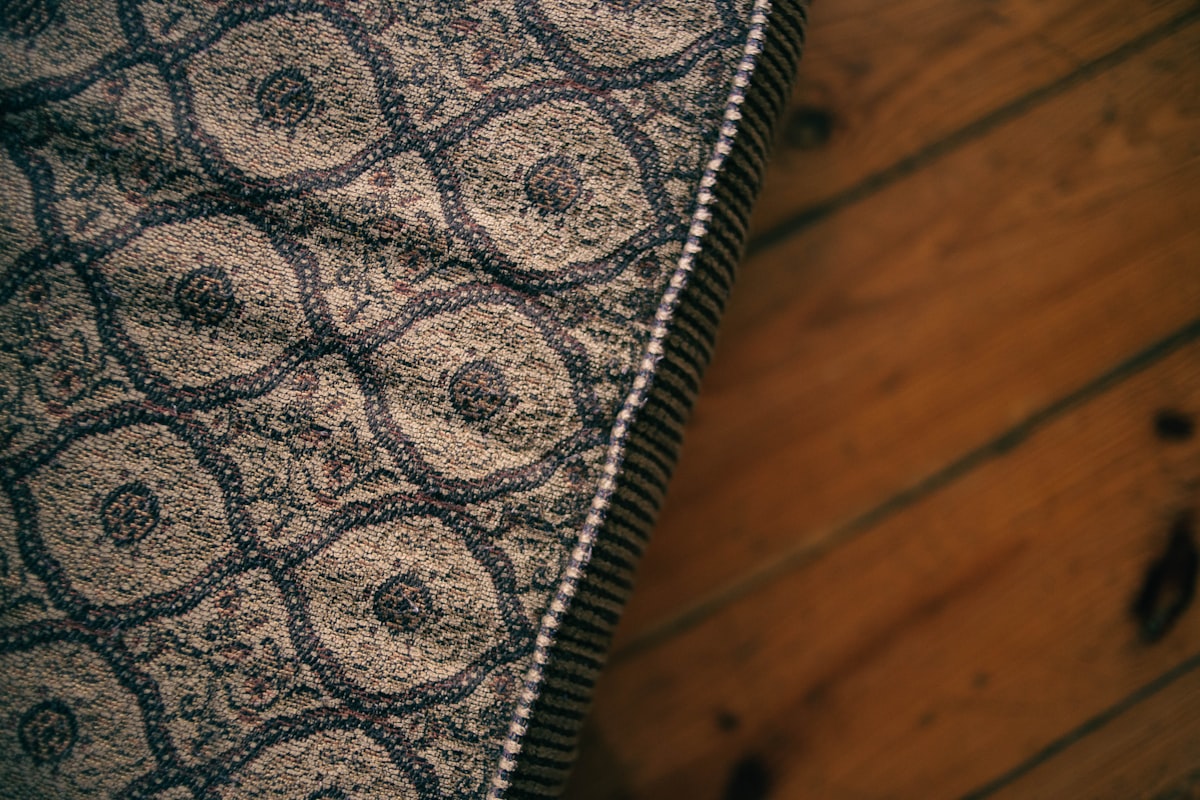 a close up of a rug on a wooden floor related to Scalloped Matelasse Coverlet: Stylish Bedding Solution