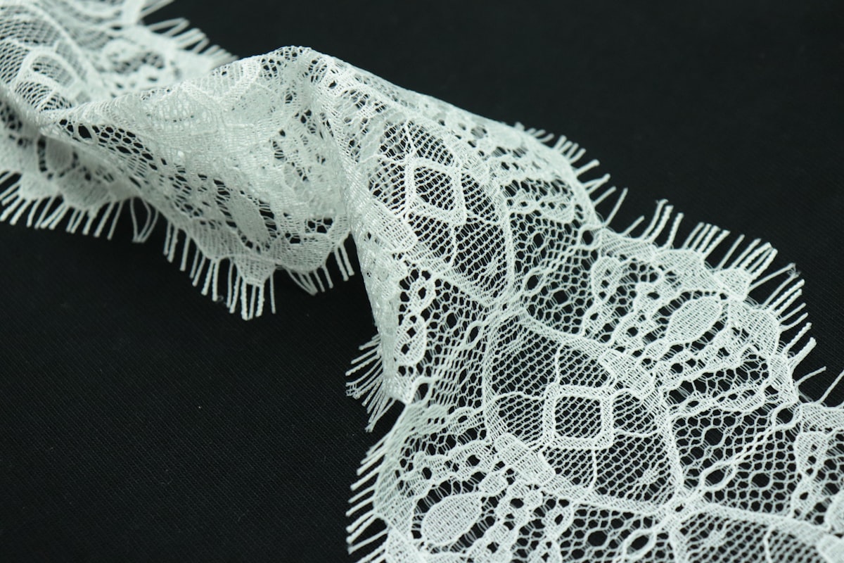 a close up of a white lace on a black background related to Elegant Touch of White Lace: Exploring the Beauty of White Lace Window Valances