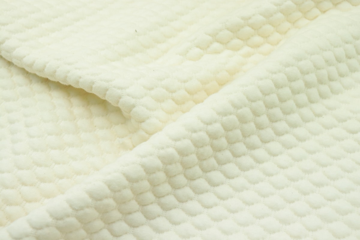a close up of a white quilted material related to Ivory Matelassé Coverlet