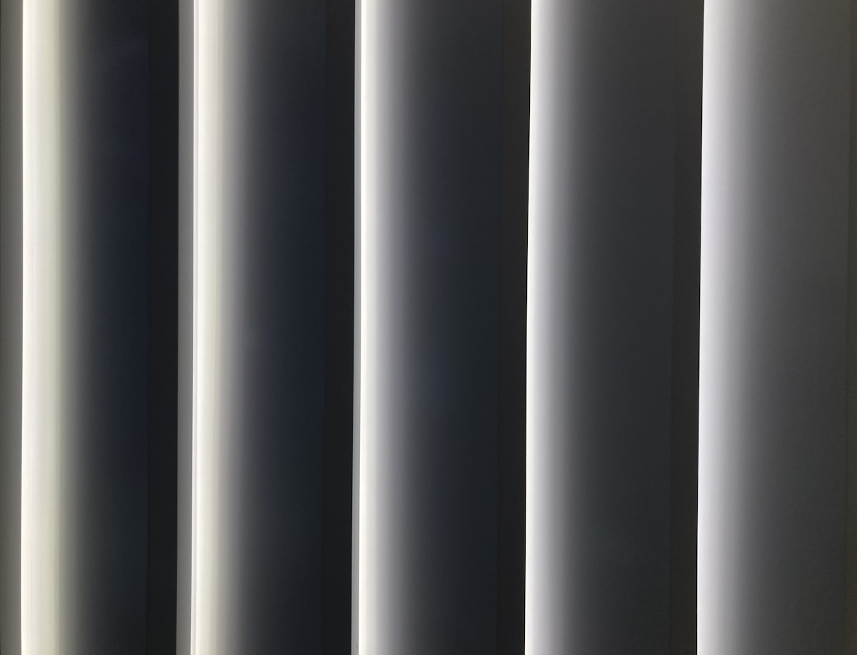 a close up of a window with vertical blinds related to Gray and White Valance: A Comprehensive Guide