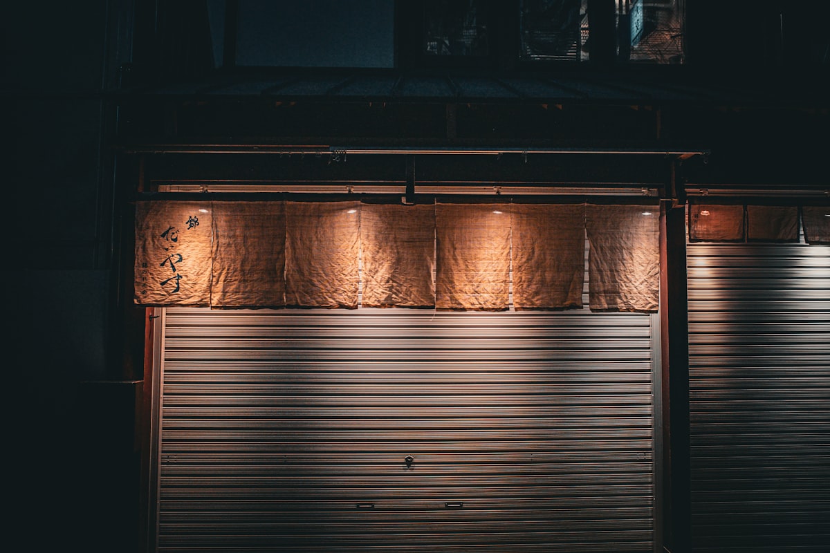 A closed garage door at night with lights on related to Gray Window Valance