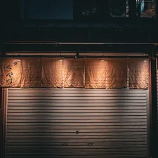 A closed garage door at night with lights on related to Gray Window Valance