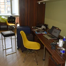 A cluttered room with a desk, chairs, and luggage. related to Essential Bed Bath and Beyond Dorm Checklist for a Smooth Move-In