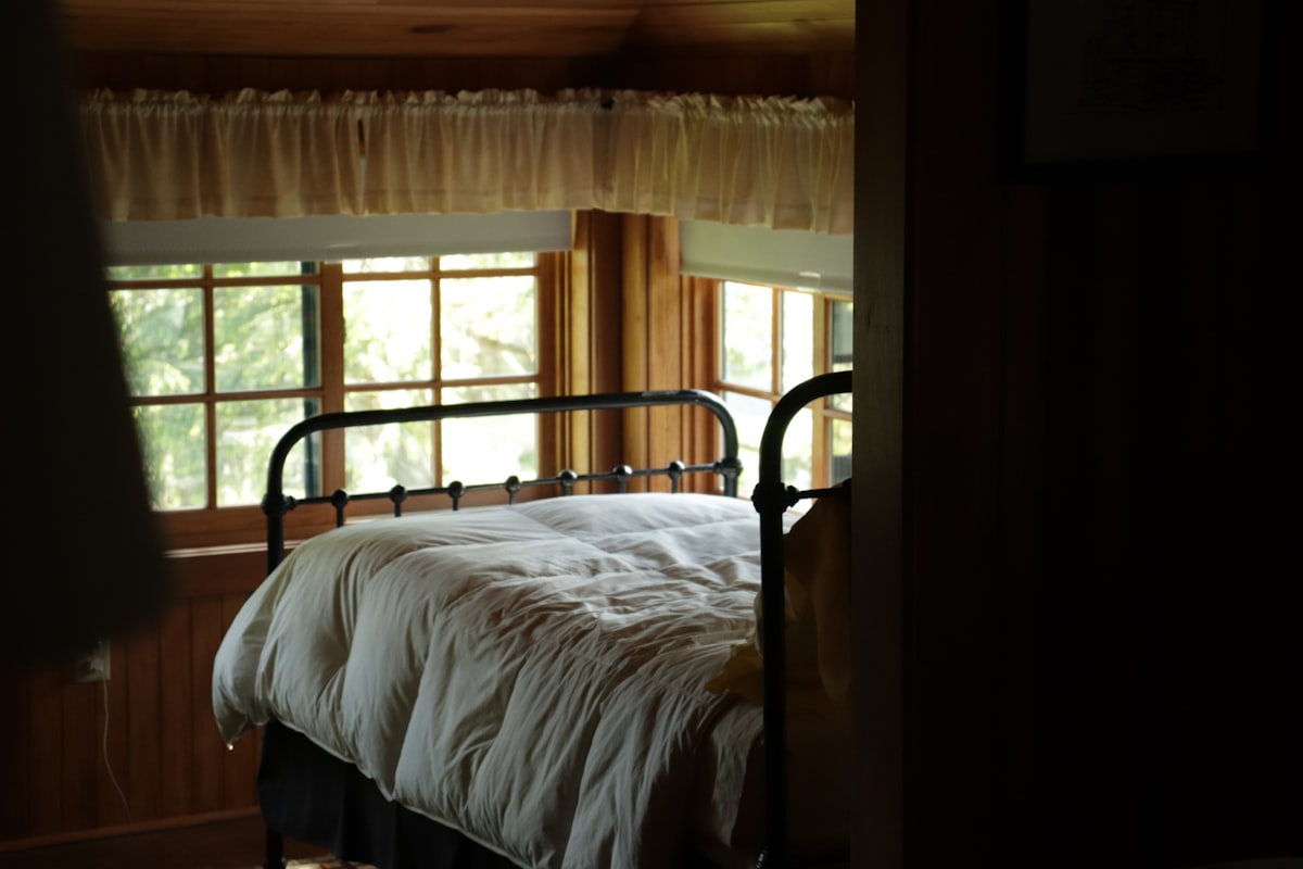 A comfortable bed by the windows. related to The Luxury of Metal Bed Frames: Upgrade Your Queen-Sized Bed