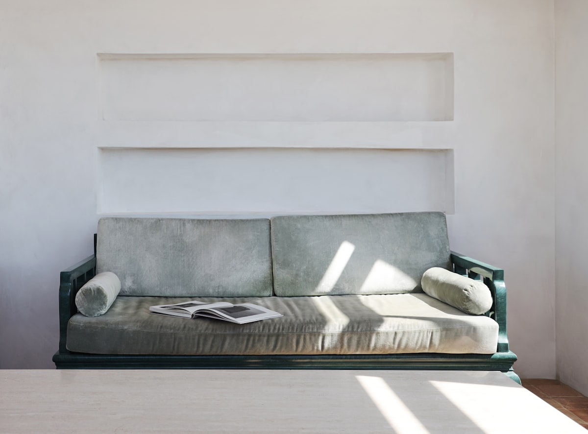 A couch sitting in a living room next to a window related to Mastering Multi-Functional Living with Convertible Sofa Beds