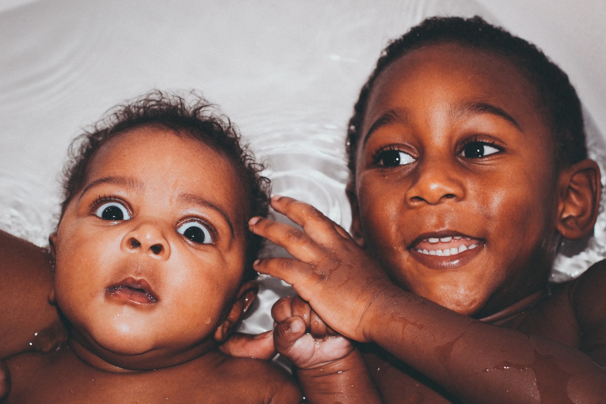 a couple of babies laying next to each other related to Soothing Spaces: Elevating Baby Care with Bed Bath & Beyond