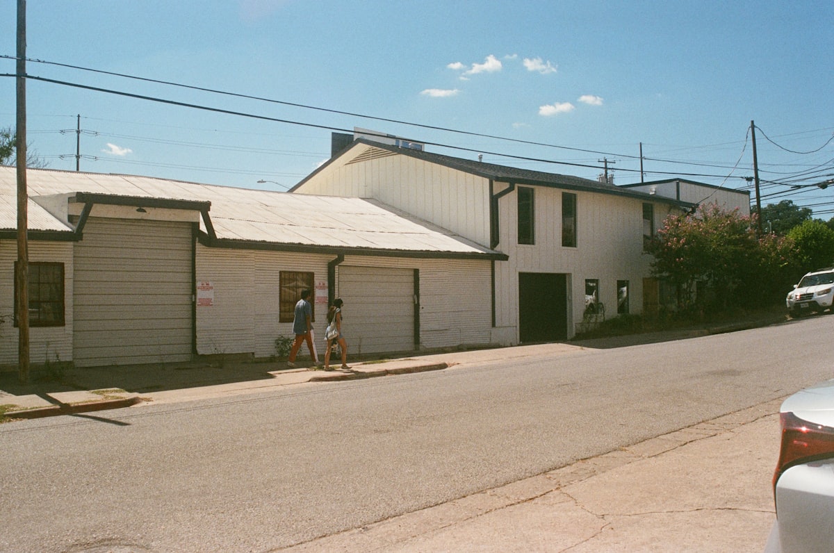 a couple of people walking down a street next to a building related to Discover the Charm of Bed and Breakfasts in Austin, Texas