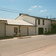 a couple of people walking down a street next to a building related to Discover the Charm of Bed and Breakfasts in Austin, Texas