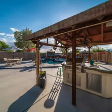 a covered patio with a grill and a table related to Transform Your Backyard with a Clay Chiminea and Barbecue Grill