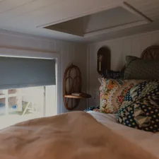 A cozy bedroom with a bed, window, and skylight. related to Elevate Your Bedroom with the Perfect Decorative Bed Pillows