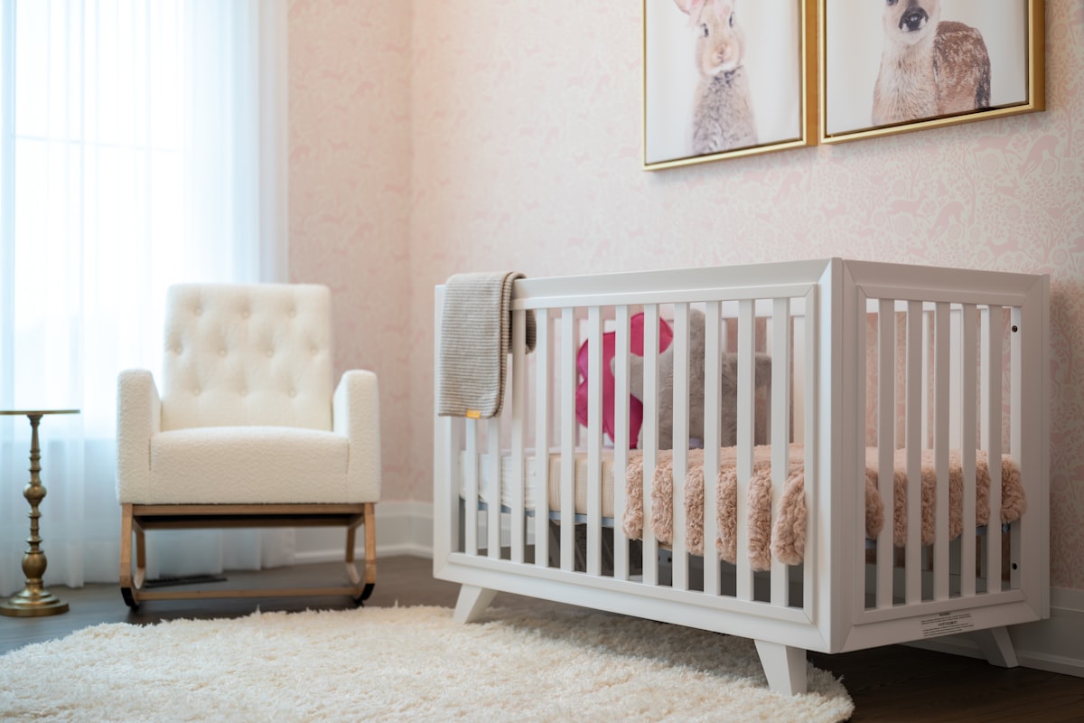 A cozy nursery with a white crib and armchair. related to Elevating Your Baby's Room with Adorable Valances