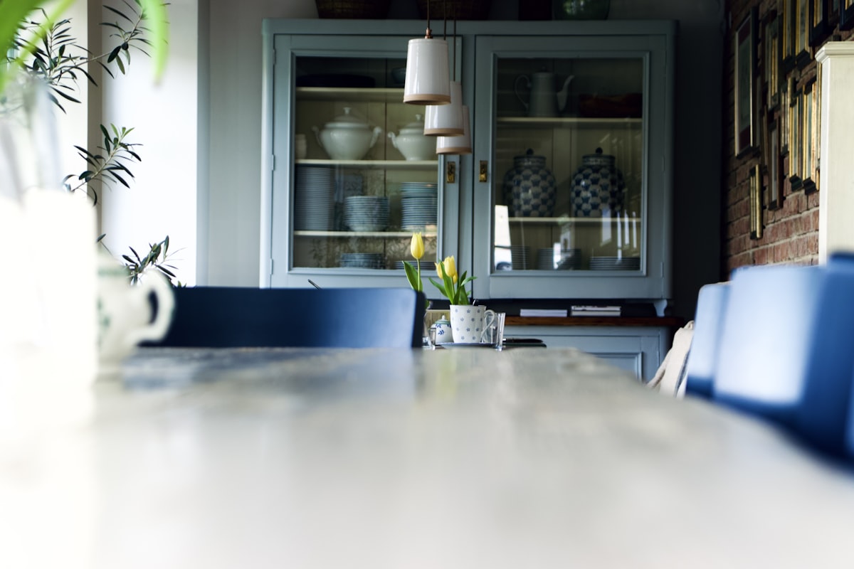 a dining room table with blue chairs and a china cabinet related to Kitchen Sideboard Table