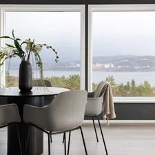 A dining room table with chairs and a vase of flowers related to Elevate Your Windows with Modern Curtain Valances